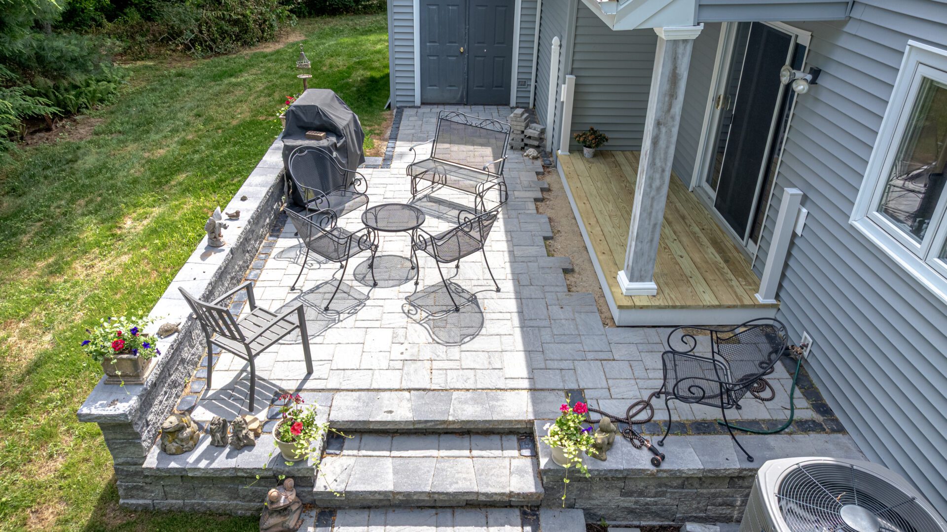Completed paver patio installation with mulch and shrubs in Connecticut